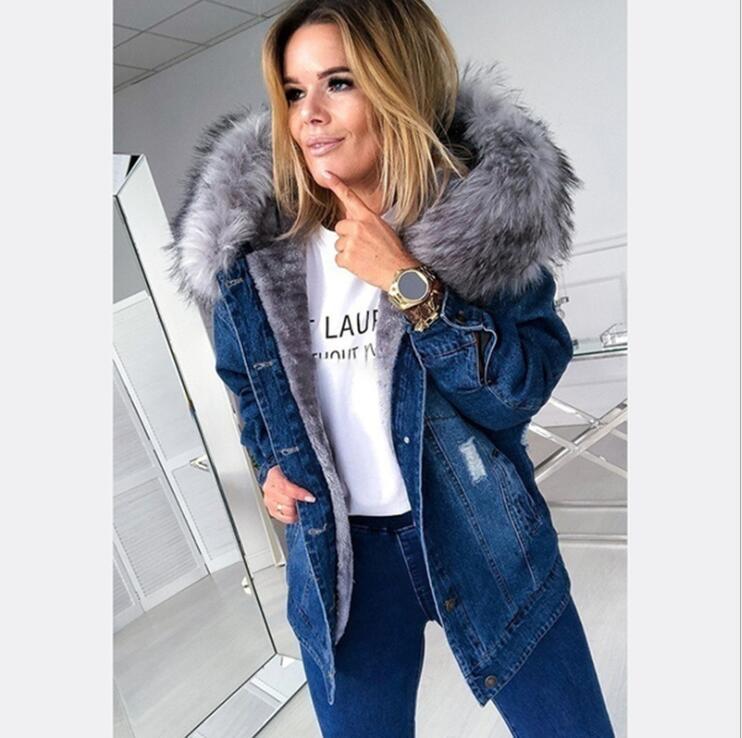 Woman wearing a denim jacket with a fur hood in an indoor setting