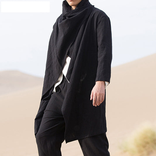 Person wearing a black outfit with a scarf in a desert setting