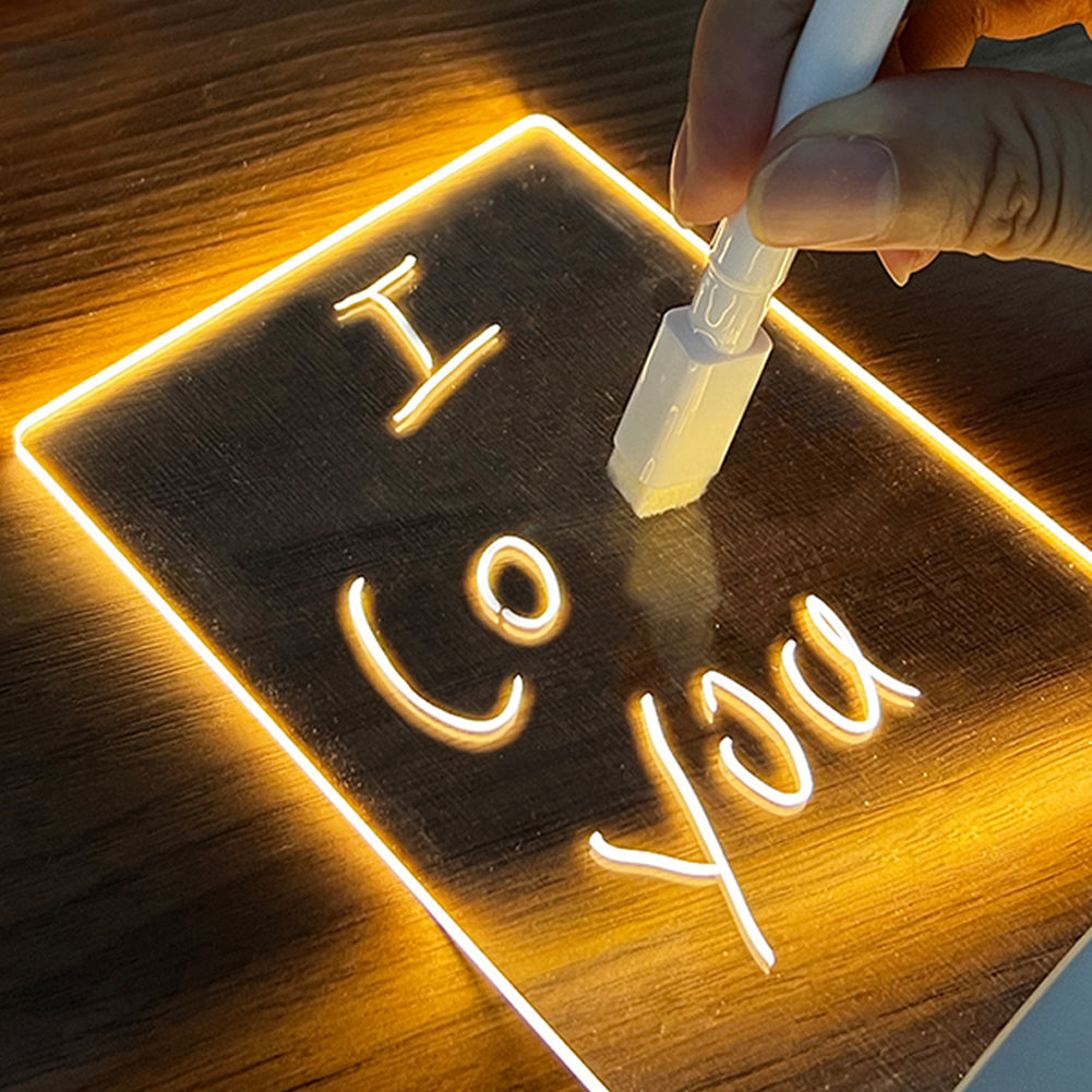 Neon sign with 'I Love You' being written on a wooden surface