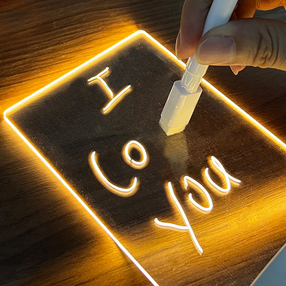 Neon sign with 'I Love You' being written on a wooden surface