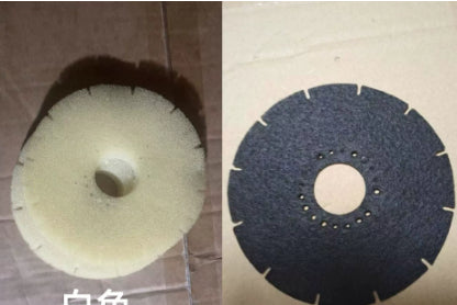 Two grinding wheels, one white and one black, on a textured surface.